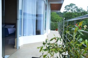 a balcony of a house with a bed in it at The Capitol Homestay in Pīrmed