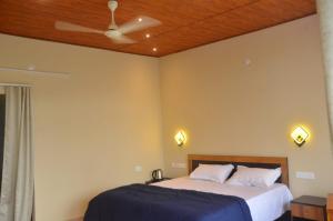 a bedroom with a bed and a ceiling fan at The Capitol Homestay in Pīrmed