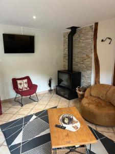a living room with a couch and a fireplace at le tilleul in Caumont