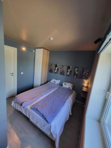 a bedroom with a large bed with purple sheets at Local home apartment in Stavanger in Stavanger