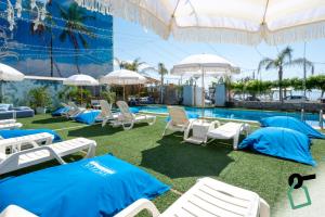 a pool with chairs and umbrellas next to a resort at Hotiday Taormina Mazzeo in Taormina