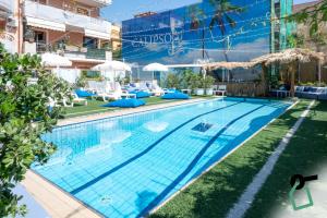 a pool with chairs and umbrellas next to a building at Hotiday Taormina Mazzeo in Taormina
