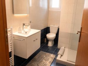 a white bathroom with a toilet and a sink at Angel Luxury Apartments in Keramoti +57 photos