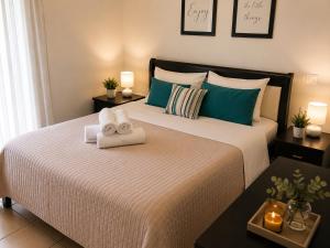a bedroom with a large bed with towels on it at Angel Luxury Apartments in Keramoti