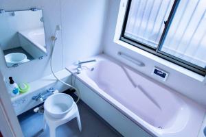 a bathroom with a tub and a toilet and a window at 古民家一棟貸 鴨部巣 kamobese in Kochi +11 photos
