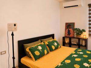 a bedroom with a bed with green sheets and pillows at Mun Room in Hai Phong