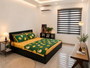 a bedroom with a bed with a green blanket and a window at Mun Room in Hai Phong