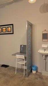 a desk with a chair and a sink in a room at Roomah Ipoh En-suite attached-Bath R2 in Ipoh