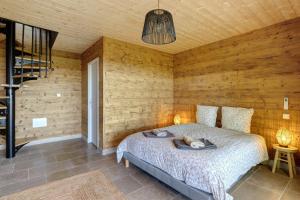 a bedroom with a bed and a wooden wall at Lodge Spa Celeste in Sarlat-la-Canéda