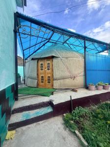 a building with a yurt on the side of a building at Guest House Oimo in Balykchy