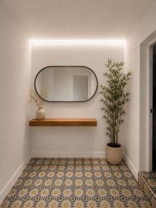 a mirror on a wall next to a floor with a plant at Casa Antares Granada in Granada