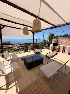 a patio with chairs and tables and a view of the ocean at Enamórate con vistas al mar en La Marina House in La Alcazaba