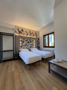 two beds in a room with wooden floors at LEON D'ORO - Art Hotel in Pieve di Soligo +16 photos