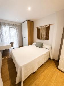 a bedroom with a large white bed and a desk at Tranquilo in Elche