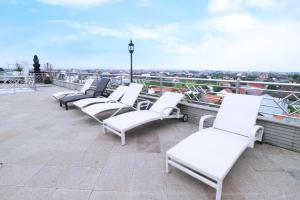 a row of white chairs sitting on top of a roof at Bali Paradise City Hotel in Denpasar