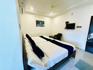 a bedroom with a bed and a tv on the wall at MGR RESIDENCY in Srikalahasti