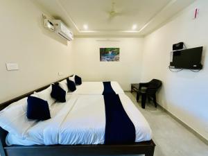 a bedroom with a large white bed with blue pillows at MGR RESIDENCY in Srikalahasti +26 photos