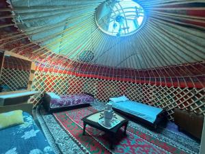 a room with beds and a table in a room at Guest House Oimo in Balykchy