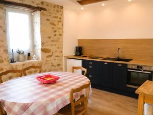 a kitchen with a table with a red tray on it at La Maison des Filles in Sainte-Scolasse-sur-Sarthe
