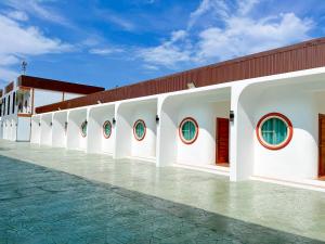 a white building with a row of windows at Aten hotel in Sathani Khao Pip