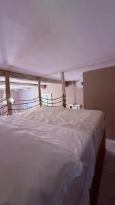 a bedroom with a large bed with white sheets at Casa Everest in Malgrate