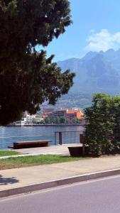two benches on a sidewalk near a body of water at Casa Everest in Malgrate