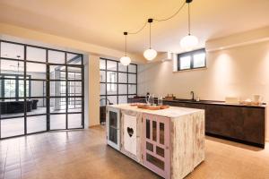 a kitchen with a island in the middle of a room at L'Attico di Asilo in Barolo in Barolo +35 photos