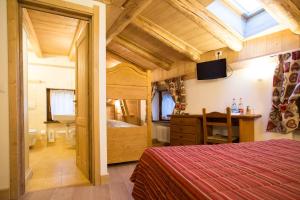 a bedroom with a bed and a desk in a room at Hotel Restaurant La Barme in Cogne
