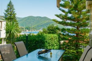 a blue table and chairs on a balcony with a tree at Apartments Danilo in Herceg-Novi