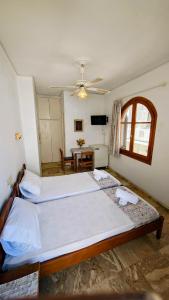 a bedroom with two beds and a table in it at Achilleion-Edipsos in Loutra Edipsou +24 photos