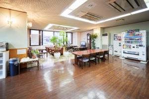 a large room with wooden floors and tables and chairs at Hotel Select Inn Furukawa in Osaki