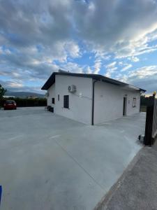 a large white building with a parking lot at Affittacamere Sisca Oriolo in Schiavonea