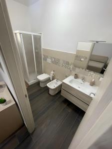 a bathroom with two sinks and a toilet and mirror at Affittacamere Sisca Oriolo in Schiavonea +31 photos