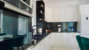 a kitchen with white cabinets and black counter tops at Luxury Villa Domino with Heated Pool in Mostar +58 photos