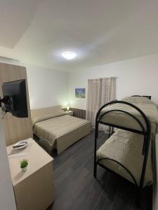 a bedroom with two bunk beds and a television at Affittacamere Sisca Oriolo in Schiavonea