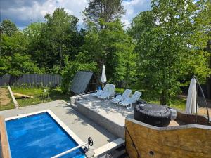 a swimming pool with two lounge chairs and a tire at Villa Kristal Slatina- Private Pool & Jacuzzi BBQ in Slatina Varoš