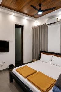 a bedroom with a bed with a ceiling fan at SRK luxe resort in Maivādi Road +17 photos