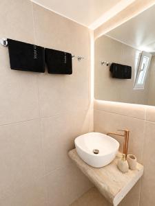 a bathroom with a white sink and black towels at Sunset studio in Plaka in Plaka Milou