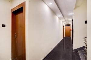 a hallway with a wooden door and a staircase at Super Collection O Zero Mile Patna Formerly Chandrashila Residency in Gulzārbāgh +31 photos