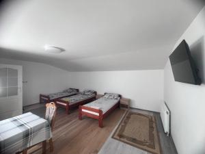 a living room with two beds and a flat screen tv at Gospodarstwo Agroturystyczne E K Szabowscy in Jeżewo