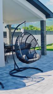 a hammock chair on a patio with a porch at Luxury Villa Domino with Heated Pool in Mostar