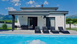 a villa with a swimming pool next to a house at Luxury Villa Domino with Heated Pool in Mostar