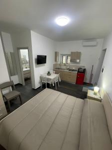 a living room with a bed and a kitchen at Affittacamere Sisca Oriolo in Schiavonea