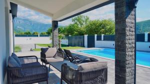 a patio with chairs and a swimming pool at Luxury Villa Domino with Heated Pool in Mostar