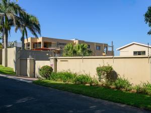 a fence in front of a house with palm trees at Seagull Villa in Margate