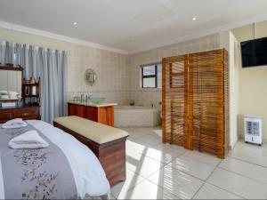 a bedroom with a bed and a tub and a television at Seagull Villa in Margate