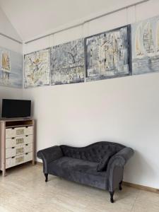 a couch sitting in a living room with a tv at Apartament Art & Lake View in Gryzliny