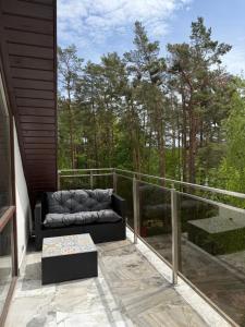 a couch on the balcony of a house at Apartament Art & Lake View in Gryzliny