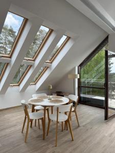 a dining room with a table and chairs and windows at Apartament Art & Lake View in Gryzliny +17 photos
