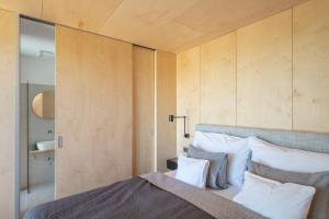 a bedroom with a bed and wooden walls at Kapolcsi Sziklák in Vigántpetend +19 photos